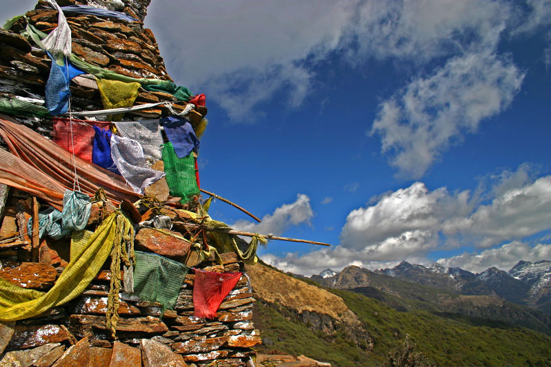 Prayer flags and a chorten at a mountain pass on the Druk Path Trek, Bhutan